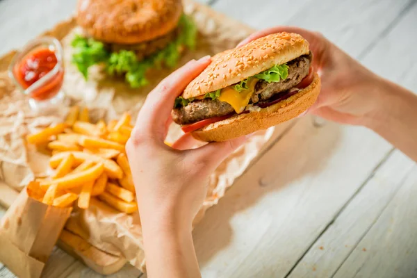 Klasszikus nagy hamburger kezében. — Stock Fotó