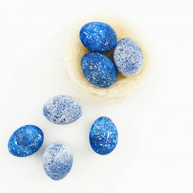 Mavi benekli Paskalya yumurtası ve beyaz arka plan üzerinde izole yuva. Düz yatıyordu. Üstten Görünüm