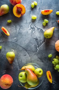 Çerçeve, şeftali, armut ve üzüm karanlık masada. Meyve kavramı. Düz yatıyordu, en iyi görünümü