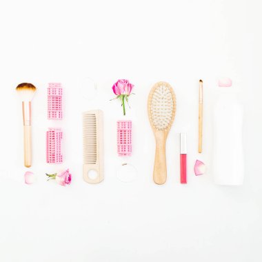 Çerçeve için curlers, styling saç tarak ile yapmak için fırçalar ve beyaz arka plan üzerinde pembe güller. Güzellik blog kompozisyon. Düz yatıyordu, en iyi görünümü