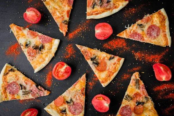 Italian pizza with ingredients. Flat lay, top view. Pizza chips pattern on dark table