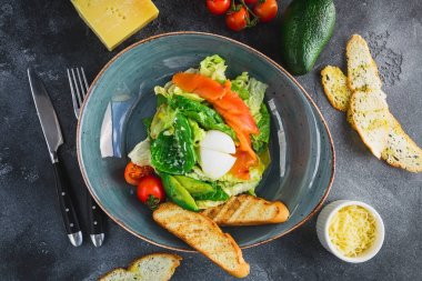 Sezar salatası yumurta, somon, avokado, kiraz domates ve kızarmış ekmek