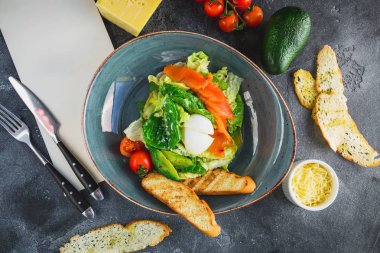 Sezar salatası yumurta, somon, avokado, kiraz domates ve kızarmış ekmek