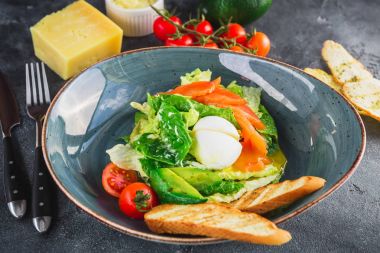 Sezar salatası yumurta, somon, avokado, kiraz domates ve kızarmış ekmek