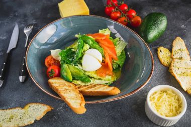 Yumurta, somon, avokado, domates ve ızgara tost, Sezar salatası görünümü kapatın. Kafede lezzetli yemekler