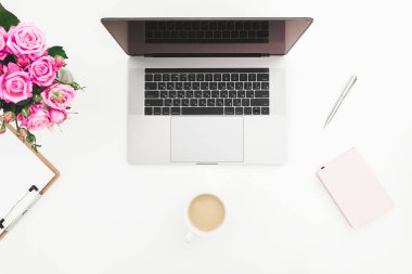 Laptop, fincan kahve, gül buketi ve farklı şeyler ile çalışma alanı'nın Üstten Görünüm 
