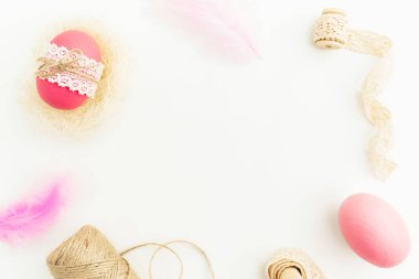 Şeritler, iplik ve tüyler ile pembe renklerde dekore edilmiş yumurtalı Paskalya kompozisyon