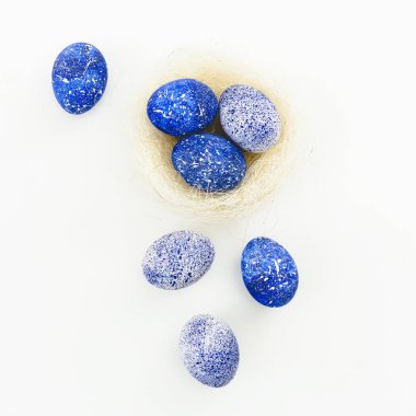 Beyaz zemin üzerine mavi benekli Paskalya yumurtaları. Düz yatıyordu. Üstten Görünüm