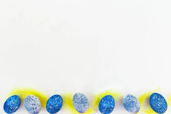 Blue Speckled Easter Eggs Penas Amarelas Fundo Branco Deitado Vista — Fotografia de Stock