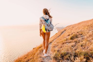 Genç çekici kadın sarı elbise ve doğada beyaz spor ayakkabı. Kusursuz bir beden ile kadın