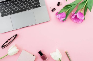 Ofis büro dizüstü bilgisayar, Beyaz Lale, gözlük, kalem ve pembe bir arka plan için makaslar. Düz yatıyordu. Üstten Görünüm. Kopya alanı ile serbest meslek kompozisyon.