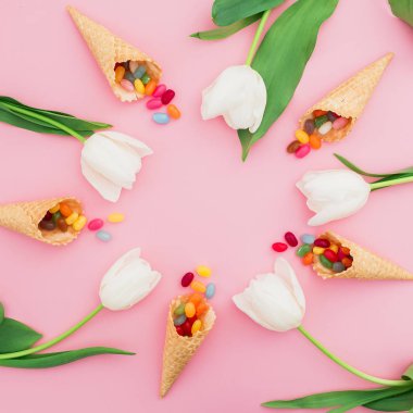 Lale ve pembe bir arka plan üzerinde renkli şekerler çiçek kompozisyonu. Düz yatıyordu, en iyi görünümü