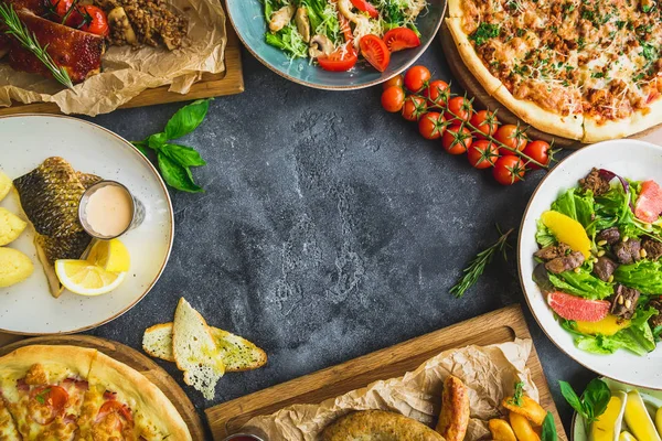 Pratos Saborosos Mesa Escura Costeletas Porco Grelhadas Pizza Saladas Peixe — Fotografia de Stock