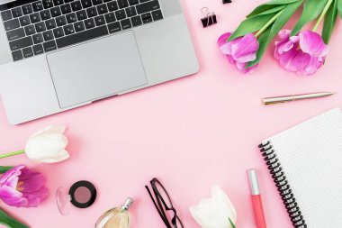 Ofis büro dizüstü bilgisayar, Beyaz Lale, gözlük, kalem ve pembe bir arka plan için makaslar. Düz yatıyordu. Üstten Görünüm. Kopya alanı ile serbest meslek kompozisyon.
