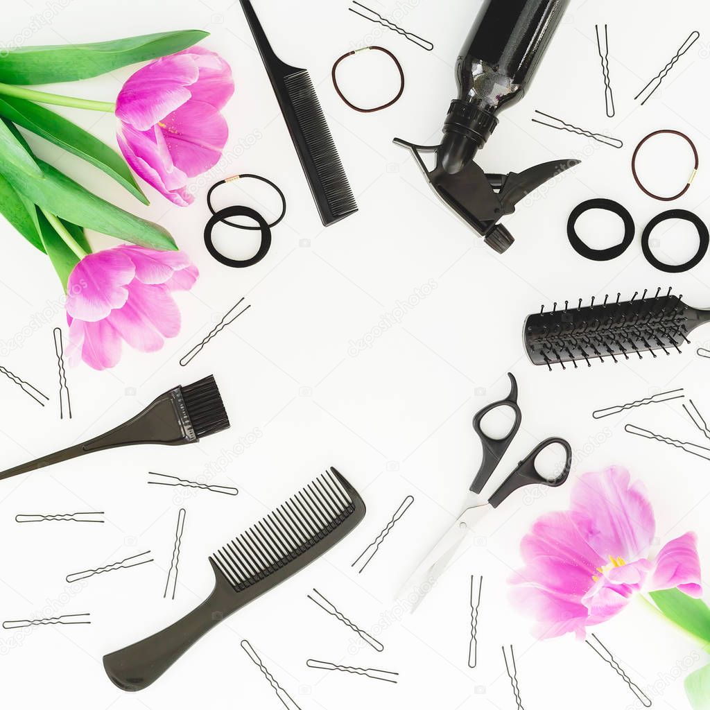 Frame with hairdresser tools - spray, scissors, combs, barrettes and tulips flowers on white background. Flat lay, top view
