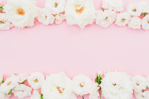 Floral frame made of white flowers on pink background. Flat lay, Top view. Valentines day background
