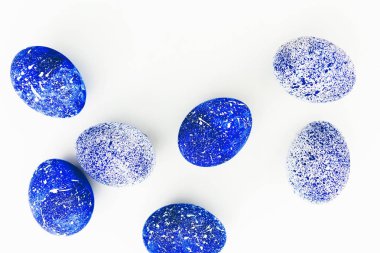 Beyaz zemin üzerine mavi benekli Paskalya yumurtaları. Düz yatıyordu. Üstten Görünüm