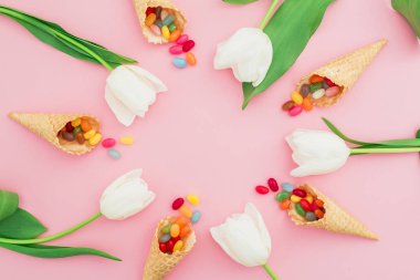 Lale ve pembe bir arka plan üzerinde renkli şekerler çiçek kompozisyonu. Düz yatıyordu, en iyi görünümü