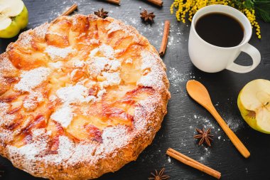 Charlotte pasta, kahve kupa, tarçın ve Mimoza çiçekler koyu arka plan üzerinde. 