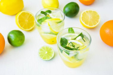 Ihlamur, nane ve limon beyaz masada bardaklarda narenciye limonata