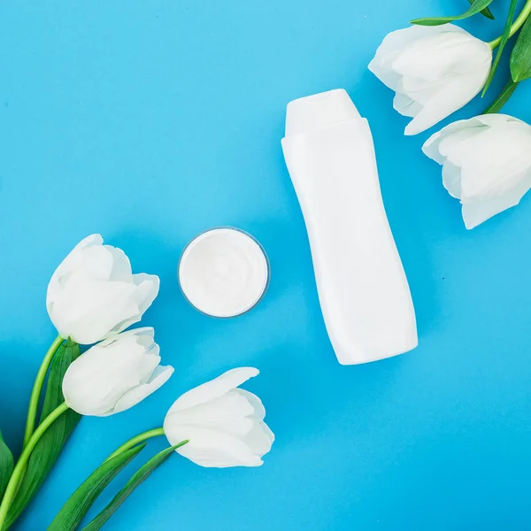 Vista Superior Varios Productos Cosméticos Con Tulipanes Sobre Fondo Azul — Foto de Stock