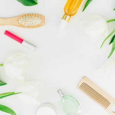 Beyaz arka plan üzerinde kozmetik, parfüm, tarak ve Lale çiçekler