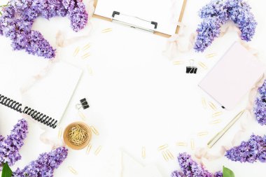 Beyaz arka plan üzerinde dizüstü bilgisayarlar, klipler ve taze leylak çiçekler Üstten Görünüm