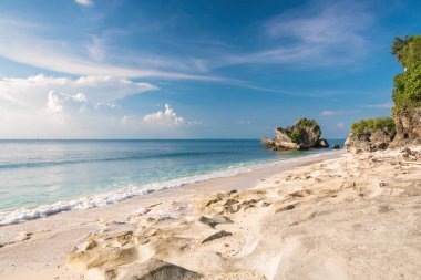 Doğal görünümü bulutlu gökyüzü altında mavi okyanus ve kumlu plaj