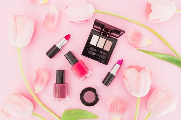 Composition with cosmetics products and pink tulips on pink background