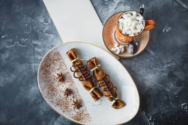 Tarçın ve beyaz tabakta anason ile çikolatalı krep