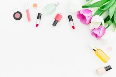 Şişeler, ruj ve oje beyaz arka plan üzerinde izole güzel beyaz çiçeklerin Üstten Görünüm