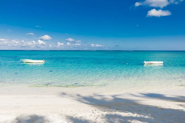 Тропический пляж с прозрачным океаном и лодкой на Маврикии — стоковое фото
