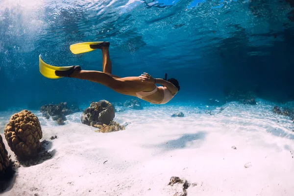 Lány freediver siklik sárga uszonyok felett homokos tenger. — Stock Fotó