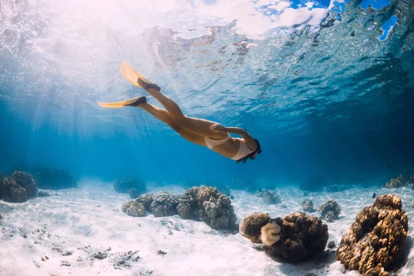 Lány freediver siklik sárga uszonyok felett homokos tenger. — Stock Fotó