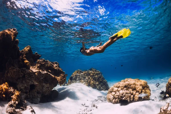 Nő freediver siklik át a homokos tenger sárga uszonyok transp — Stock Fotó