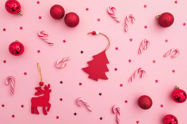 クリスマスまたは新年の組成物。赤いおもちゃ、キャンディーの杖と詐欺師 — ストック写真