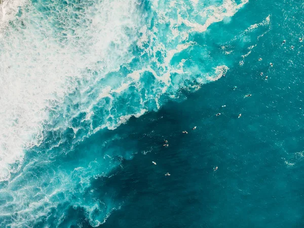 Widok z lotu ptaka z surferami i falą w kryształowym oceanie. Widok z góry — Zdjęcie stockowe