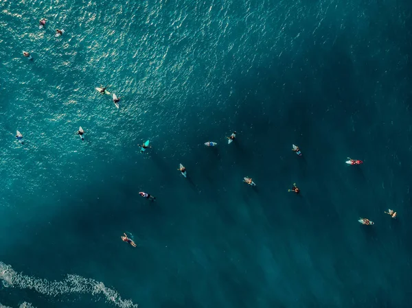 Aerial view with surfers and wave in crystal ocean. Top view — Stock Photo, Image