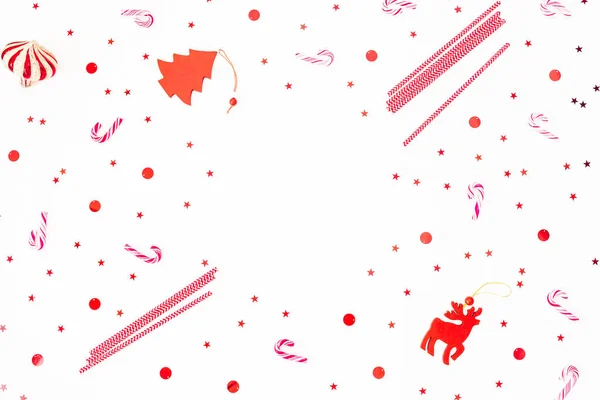 Boże Narodzenie wzór cukierków i czerwone błyszczące konfetti na białym — Zdjęcie stockowe