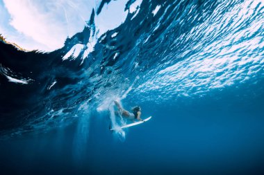 Surfer make duck dive underwater. Surfgirl dive under wave clipart