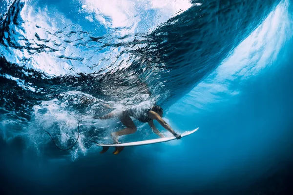 O surfista faz o pato mergulhar debaixo de água. Surfgirl mergulho sob onda — Fotografia de Stock