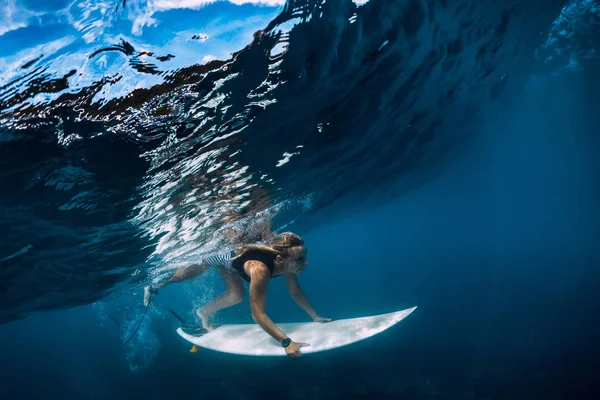O surfista faz o pato mergulhar debaixo de água. Surfgirl mergulho sob onda — Fotografia de Stock