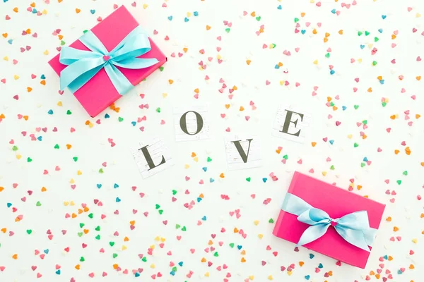 Sevgililer Günü kompozisyonu. Aşk kelimesi, hediye kutusu ve renkli. — Stok fotoğraf