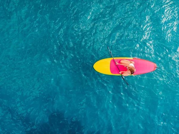 Attrayant femme en maillot de bain flottant sur stand up paddle board o — Photo