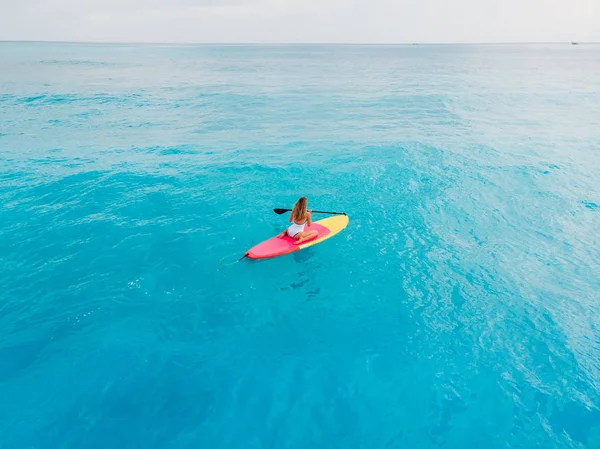 Attrayant femme en maillot de bain flottant sur stand up paddle board o — Photo