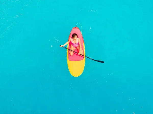 Atractiva mujer en traje de baño flotando en stand up paddle board o — Foto de Stock