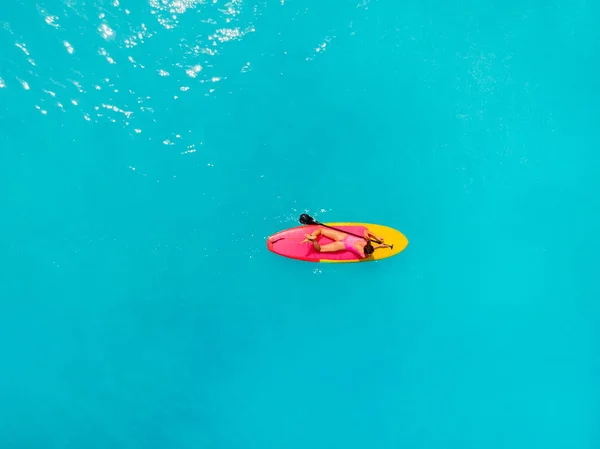 Femme séduisante se détendre sur stand up paddle board dans l'océan bleu. S — Photo