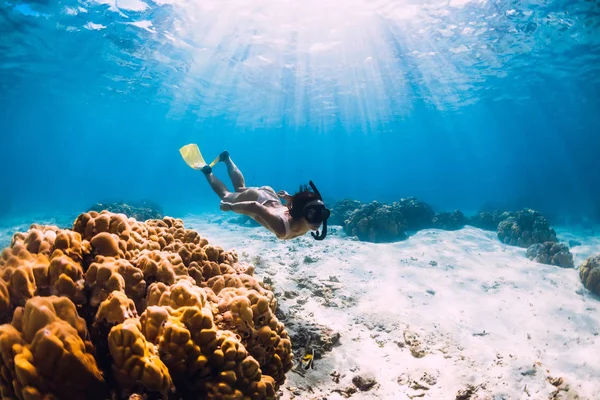 Free subacqueo giovane ragazza con pinne gialle scivola sul fondo sabbioso — Foto Stock