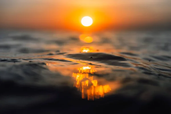 Puesta de sol y olas en el océano. Textura de agua Warmy con bokeh — Foto de Stock