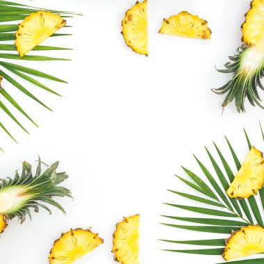 Beyaz sırtında palmiye yaprakları olan ananasla yapılmış tropik bir çerçeve.